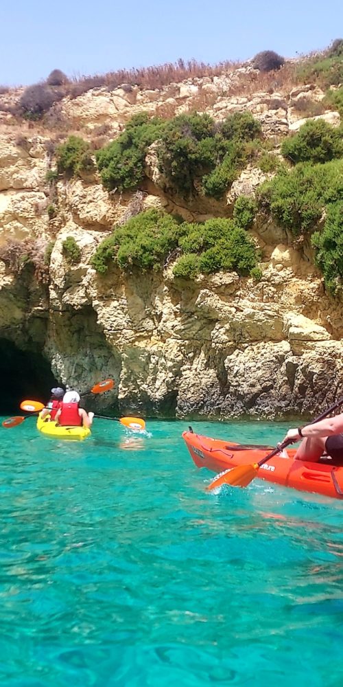 2-red-kayaks-on-turquoise-blue-water-kayaking-with-kayak-Gozo-adventures-in-Malta-aiming-for-a-cave-in-comino-1-1-scaled.